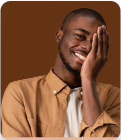 rapaz negro, cabelo raspado, sorrindo com uma das mãos cobrindo parte da face